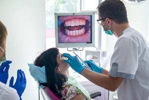 A dentist performing a checkup on a female patient