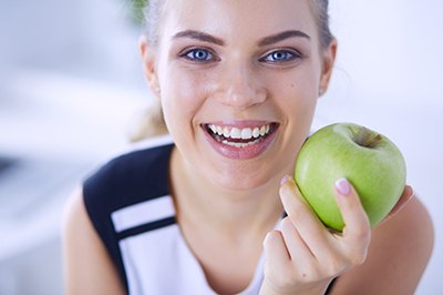 Woman with a healthy smile needing an apple. 