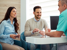 Dentist discusses something with couple