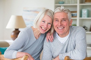 older couple in matching gray sweaters smiling