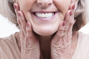 close up of older woman holding her face