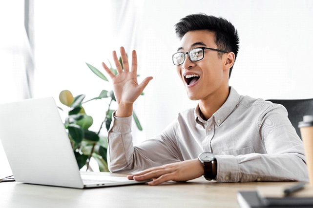 person smiling and video chatting with their friend