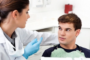 A dentist talking to a male patient