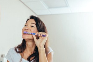 a woman brushing her teeth