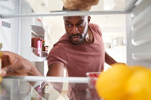 a man getting food out of his refrigerator
