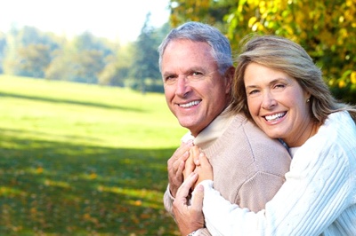 An older couple smiling outside.