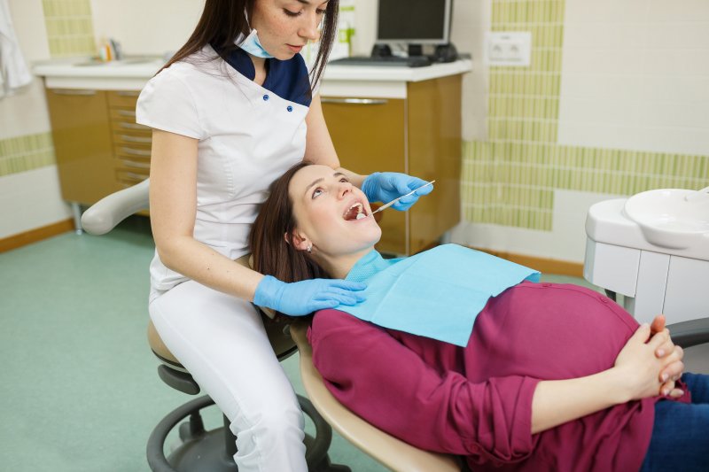 Young dentist with pregnant patient