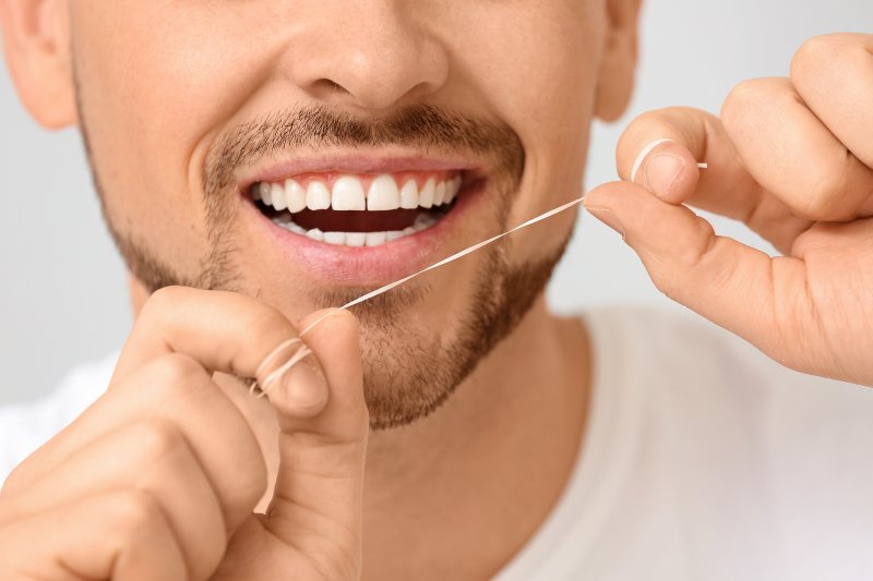 loseup of man holding dental floss