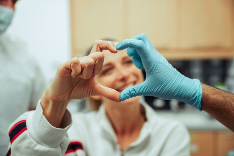 patient and dentist making a heart with hands