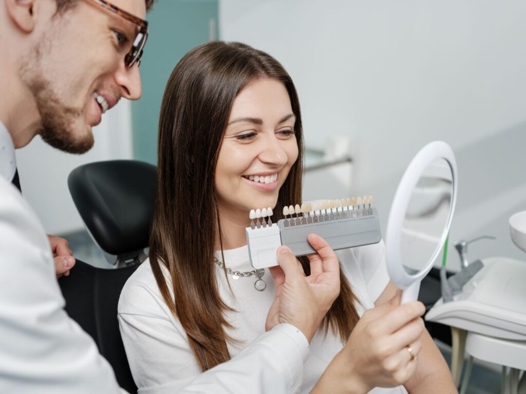 A woman looking at her smile with her dentist