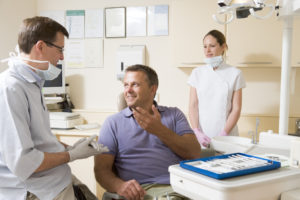 Dentist talking to man in dental chair