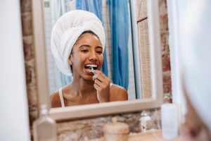 Woman flossing dental implants in Crown Point.