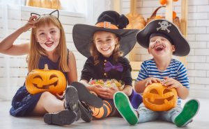 Three happy children in Halloween costumes